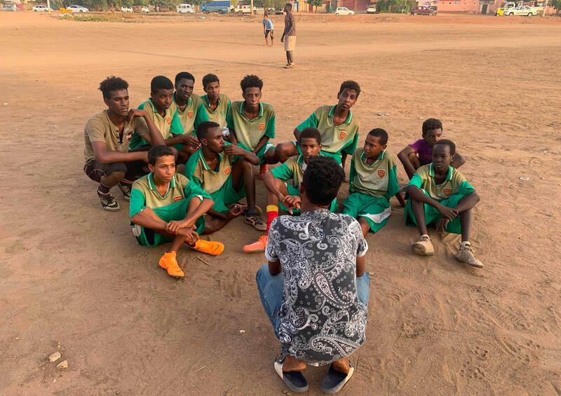 Sudanese football coach Monzer Hassan speaks with his players.
