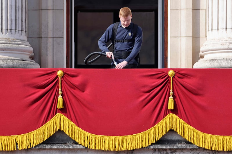 A Buckingham Palace staff member cleans the balcony where the queen is expected to wave to well-wishers. AFP