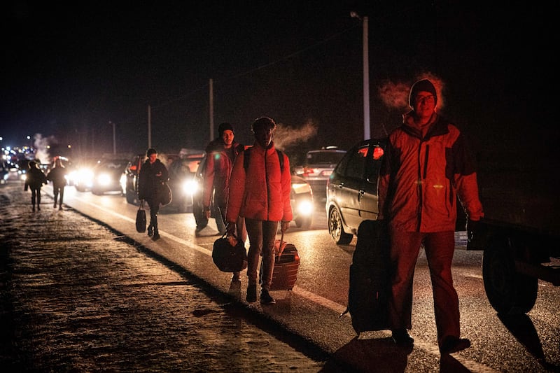 People on foot and in cars move to cross from Ukraine to Poland at the Korczowa-Krakovets border crossing following the Russian invasion of Ukraine. AFP