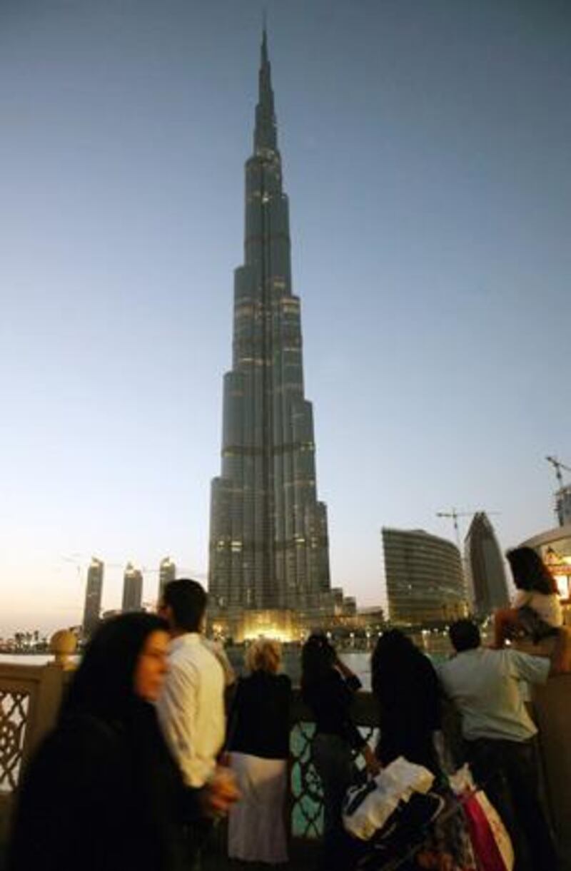 Shoppers stop to look at the Burj Khalifa during sunset in Dubai.