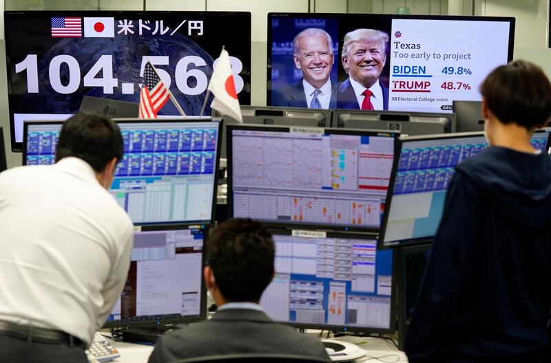 epa08797391 Money dealers discuss trade between foreign currencies as they follow the US presidential election vote count, in Tokyo, Japan, 04 November 2020.  EPA/KIMIMASA MAYAMA