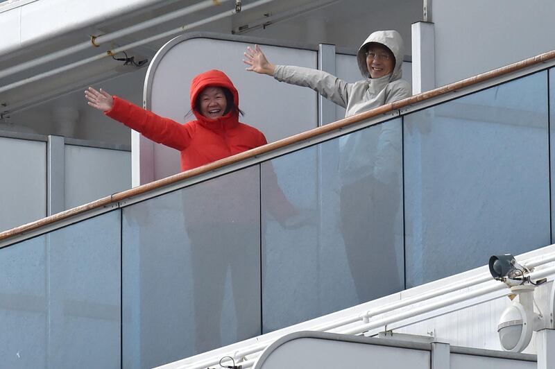 Passengers onboard the Diamond Princess cruise ship wave from their balconies as the ship docks at the Daikoku Pier Cruise Terminal in Yokohama, Japan. AFP