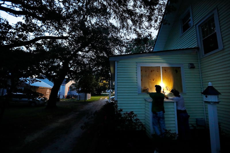Russell Meadows, left, helps neighbour Rob Muller board up his home in Morehead City, North Carolina. AP