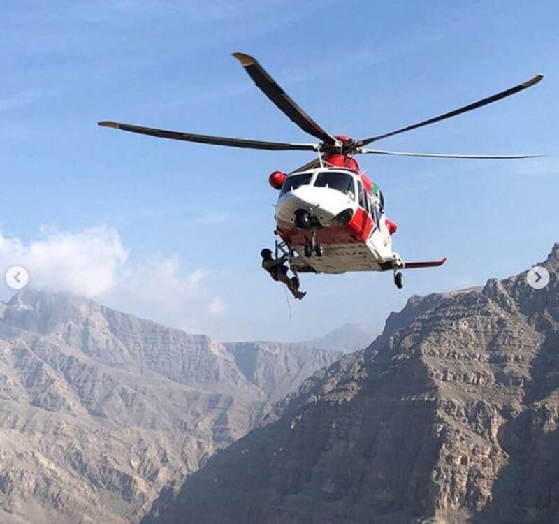 A helicopter lineman is winched into a wadi to rescue a British hiker. Courtesy: National Search and Rescue Centre