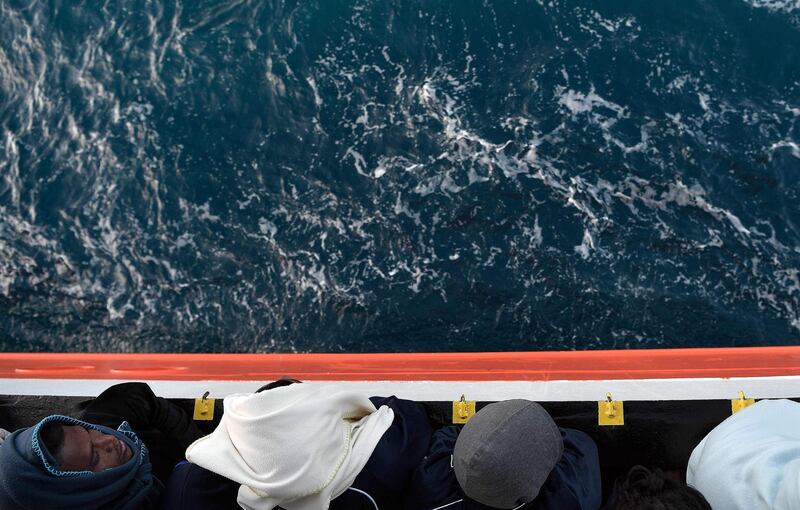 Migrants stand on the deck of the MV Aquarius, a rescue vessel chartered by SOS-Mediterranee and Doctors Without Borders, as it approaches the Italian coast. Louisa Gouliamaki / AFP