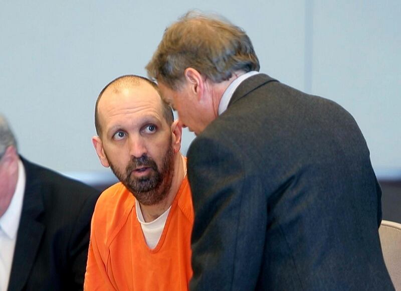 FILE - In this March 14, 2017, file photo, Craig Hicks, center, charged with the murder of three Muslim students in Chapel Hill, N.C., listens to with attorney Steve Freedman as he makes an appearance in a Durham County courtroom in Durham, N.C. Hicks is expected Wednesday, June 12, 2019, to enter a plea in court in Durham, more than four years after the slayings, which the victimsâ€™ families blamed on bigotry.  (Chris Seward/The News & Observer via AP, FIle)
