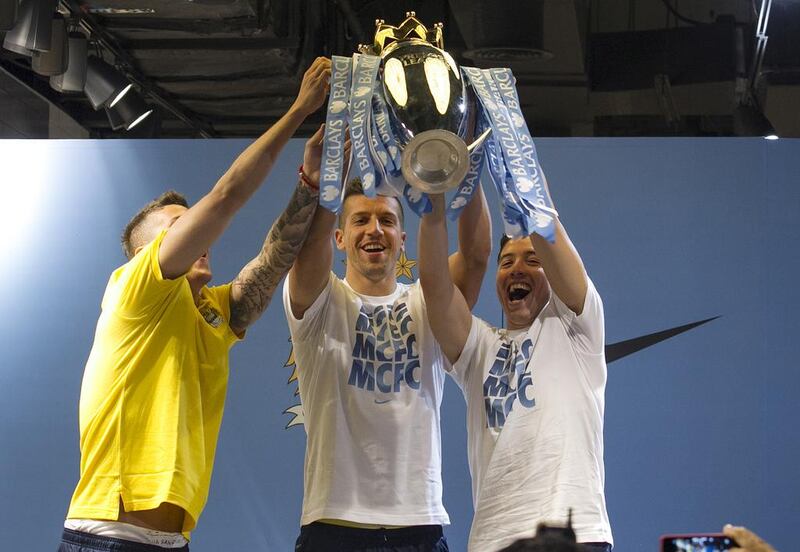 Manchester City players Samir Nasri, right, Matija Nastasic and Stevan Jovetic raise the Premier League trophy as UAE fans cheer them on during a stop at Marina Mall in Abu Dhabi on May 13, 2014. Manchester City is in the UAE capital for a friendly against Al Ain at Hazza bin Zayed Stadium in Al Ain. Mona Al Mazooqi / The National

