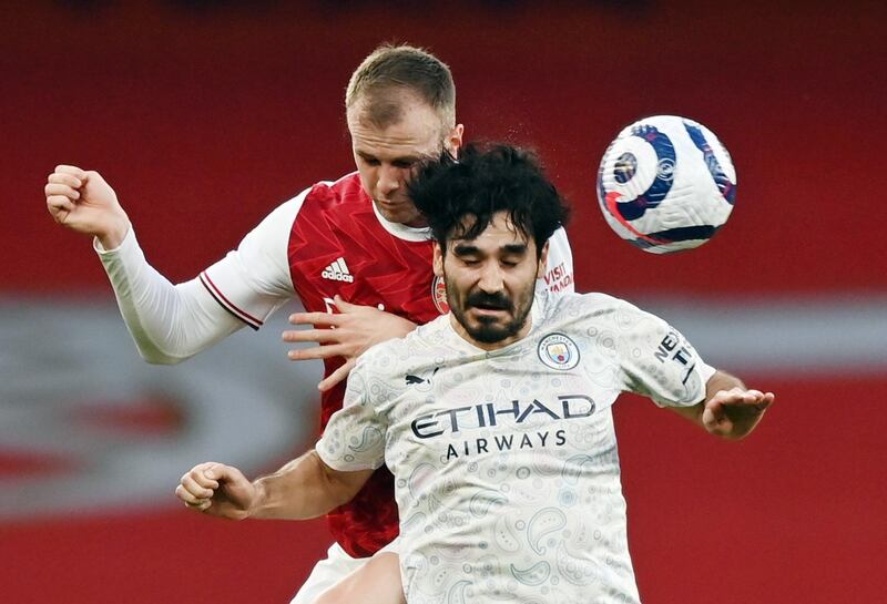 City's Ilkay Gundogan and Rob Holding of Arsenal challenge for a header. Reuters
