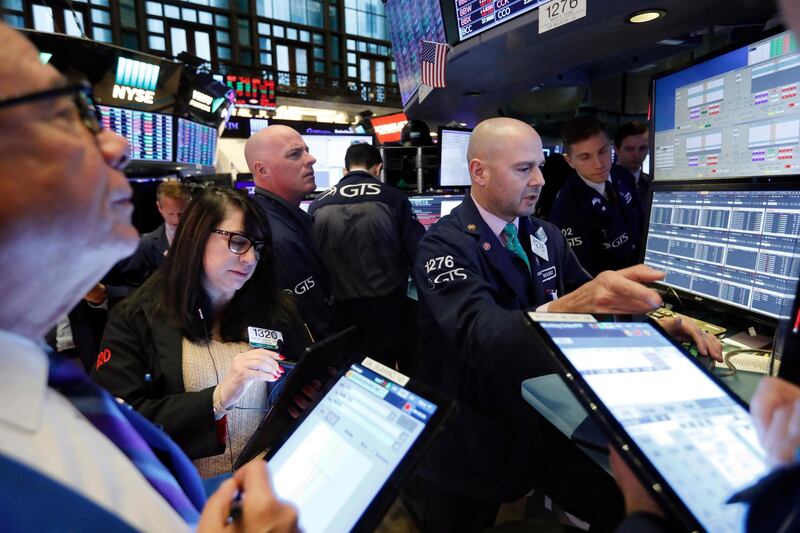 FILE - In this Nov. 20, 2019, file photo specialist Mario Picone, right, works with traders at his post on the floor of the New York Stock Exchange. The U.S. stock market opens at 9:30 a.m. EST on Tuesday, Nov 26. (AP Photo/Richard Drew, File)