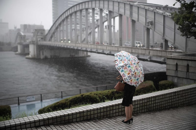 A woman protects herself from the rain with an umbrella in Tokyo.  AFP / Martin BUREAU