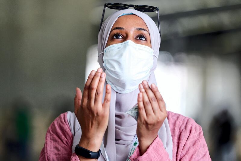 A woman Muslim pilgrim, clad in a face mask due to the COVID-19 coronavirus pandemic, prays after throwing pebbles as part of the symbolic al-A'qabah (stoning of the devil ritual) at the Jamarat Bridge during the Hajj pilgrimage in Mina, near Saudi Arabia's holy city of Mecca, on August 2, 2020. - Massive crowds in previous years triggered deadly stampedes during the ritual, but this year only up to 10,000 Muslims are taking part after millions of international pilgrims were barred because of the covid-19 pandemic crisis. (Photo by - / AFP)