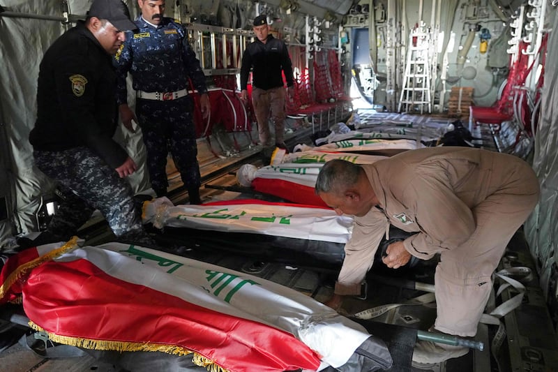 Iraqi police officers arrange the bodies of their colleagues on a plane at Kirkuk airport. AFP