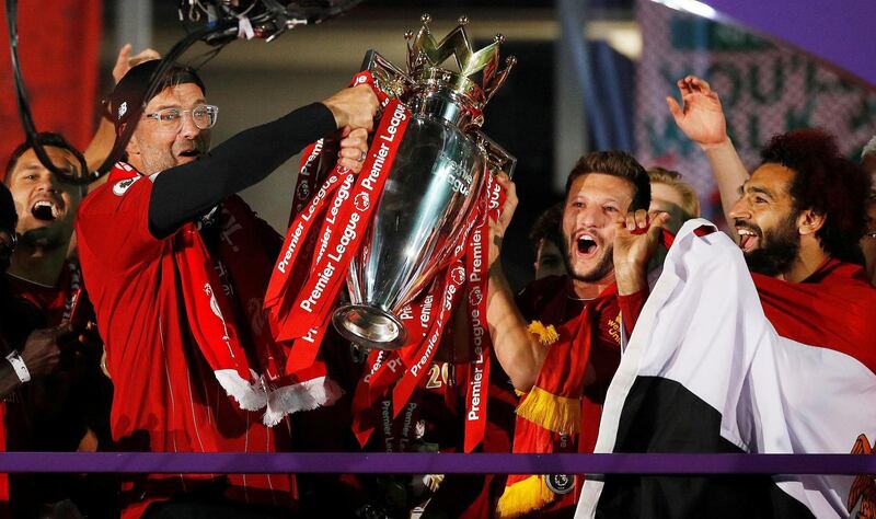 Liverpool manager Jurgen Klopp, Adam Lallana and Mohamed Salah celebrate with the trophy after winning the Premier League. Reuters