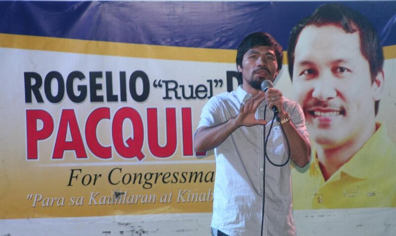 Boxing champion turned politician Manny Pacquiao with a poster of his brother Rogelio Pacquiao, who ran for congress, during a political campaign in General Santos City in southern island of Mindanao. Paul Bernaldez / AFP



