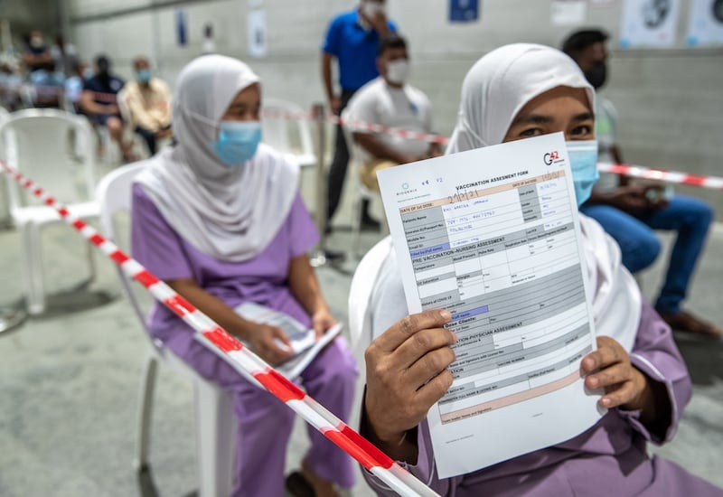Abu Dhabi residents wait to be vaccinated against Covid-19 at the Biogenix Labs at G42 in Masdar City. Victor Besa / The National