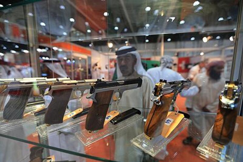 ABU DHABI - UNITED ARAB EMIRATES - 04SEPT2013 -  Visitor takes close look at guns displayed at Buerchler stall on the opening day of the Abu Dhabi International Hunting and Equestrain Exhibition 2013 yesterday at Abu Dhabi National Exhibition Centre. Ravindranath K / The National 