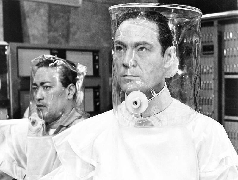 Anthony Chinn and Joseph Wiseman wearing decontamination suits in a scene from the film 'Doctor No', 1962. Courtesy United Artists