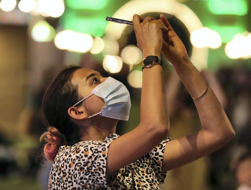 A lady watches as Global Village does the World record attempt of the highest fireworks. 20 skydivers landing in Global Village with fireworks on May 2nd, 2021. Chris Whiteoak / The National. 
Reporter: Katy Gillett for Lifestyle