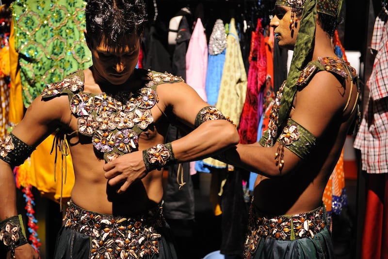 Male dancers put on their elaborate costumes for The Merchants of Bollywood musical stage show in Singapore.