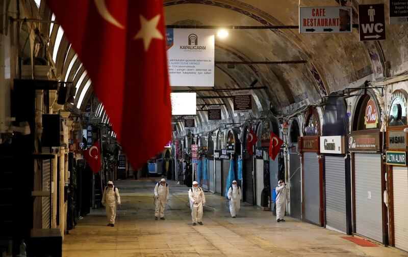 Workers in protective suits spray disinfectant at Grand Bazaar, known as the Covered Bazaar, to prevent the spread of coronavirus disease (COVID-19), in Istanbul, Turkey, March 25, 2020. REUTERS/Umit Bektas