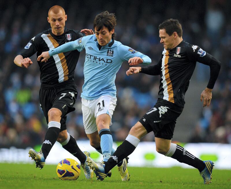 Manchester City's Spanish midfielder David Silva (C) vies with Fulham's English midfielder Steve Sidwell (L) and Fulham's German defender Sascha Riether  during the English Premier League football match between Manchester City and Fulham at the Etihad Stadium in Manchester on January 19, 2013.  AFP PHOTO/Andrew YATES - RESTRICTED TO EDITORIAL USE. No use with unauthorized audio, video, data, fixture lists, club/league logos or “live” services. Online in-match use limited to 45 images, no video emulation. No use in betting, games or single club/league/player publications. (Photo by ANDREW YATES / AFP)
