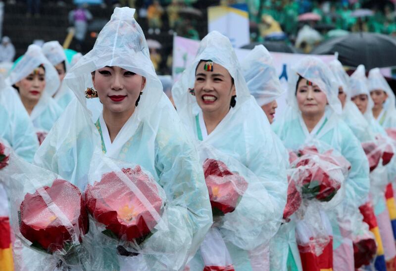Women attending a lotus lantern parade, in celebration of the upcoming birthday of Buddha, wear raincoats in the rain before the start of the parade in Seoul, South Korea. Kwak Sung-Kyung / Reuters