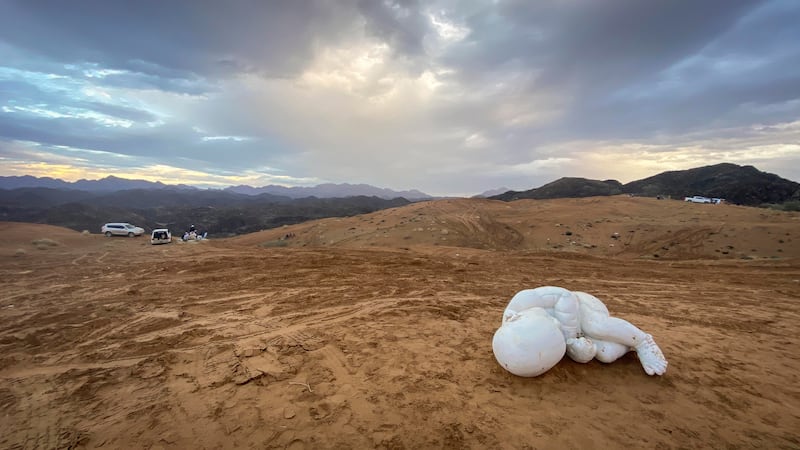 A child sculpted in marble as he cradles with a chained wrist lies in the desert sand. Sculptor Jago took the statue and abandoned it in  Fujairah. The statue, Look Down, was displayed for six months in Piazza del Plebiscito in Naples. Antonie Robertson / The National