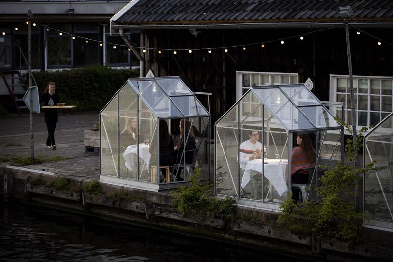 People have dinner in a so-called quarantine greenhouses in Amsterdam. AFP