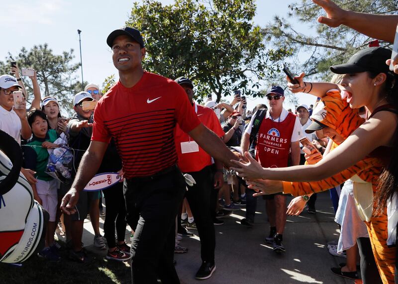 Tiger Woods greets fans as he makes his way to the seventh hole of the South Course at Torrey Pines Golf Course during the final round of the Farmers Insurance Open golf tournament, Sunday, Jan. 28, 2018, in San Diego. (AP Photo/Gregory Bull)