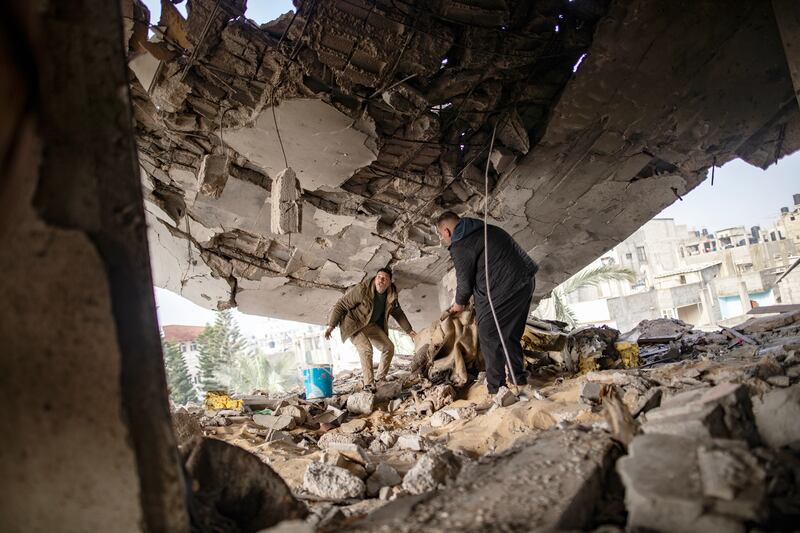 Members of the Ghannam family check the damage to their home after an Israeli air strike hit the Rafah refugee camp in the southern Gaza Strip. EPA