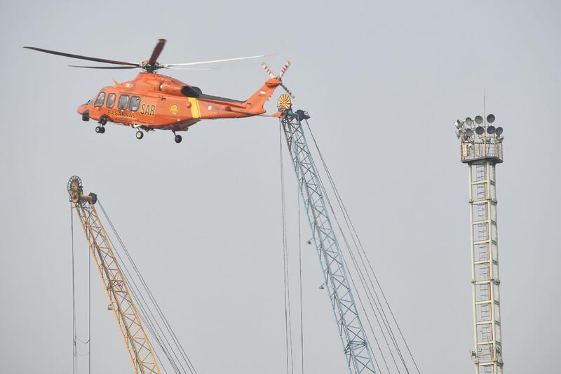 A search-and-rescue helicopter flies during an operation at the Jakarta port. AFP