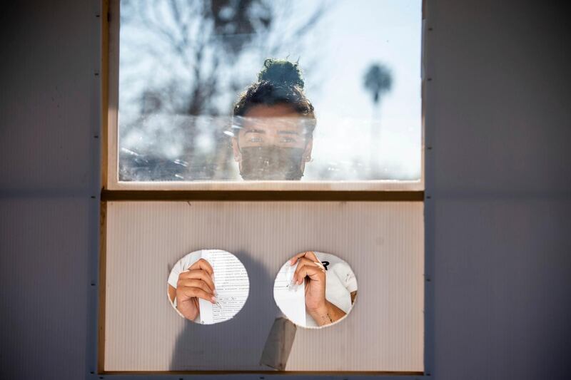 Daisy Ozaeta, 25, of Los Angeles, waits for Dr. Nana Afoh-Manina, co-founder of myCovidMD, to collect a blood sample from her for a Covid-19 antibody test. AP Photo