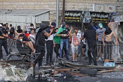 Palestinian protesters throw stones at Israeli security forces during confrontations in the Shuafat refugee camp in East Jerusalem. AFP