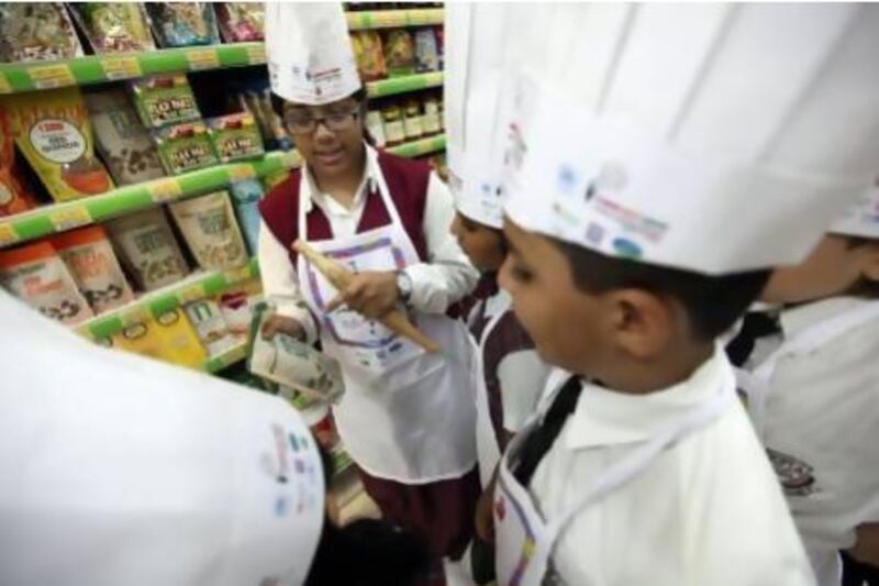 Harika Korrapati, 15, from the Emirates Future International Academy, leads a group of students on a tour of LuLu Hypermarket at Al Wahda Mall looking for organic foods part of World Environment Day yesterday. They were among 50 pupils taking part. Sammy Dallal / The National