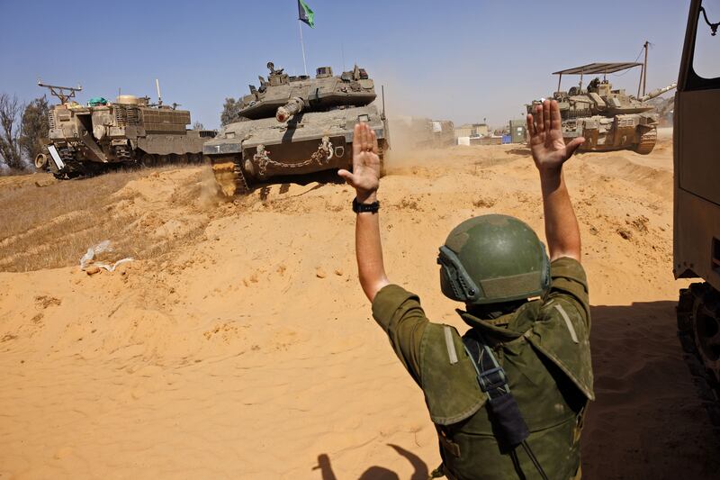An Israeli soldier directs armoured vehicles near the Rafah border crossing in the southern Gaza Strip. Bloomberg
