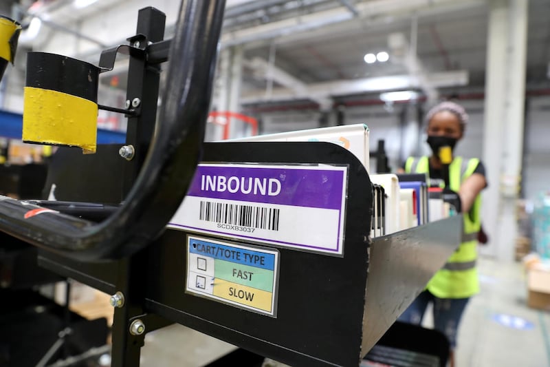 DUBAI, UNITED ARAB EMIRATES , March 18, 2021 –  Staff moving the cart at the Amazon DXB3,  Amazon fulfilment centre  in Dubai Logistics City in Dubai. (Pawan Singh / The National) For Lifestyle/Online/Instagram. Story by Farah