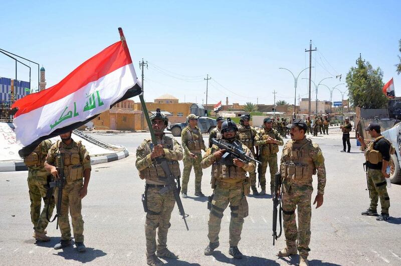 Iraqi government forces celebrate with national flags on a street on May 19, 2016 in the western town of Rutba after they recaptured it from ISIL. Rutba, located in western Anbar province along the main road to Jordan, had been held by ISIL since 2014. 

 Moadh Al Dulaimi/AFP