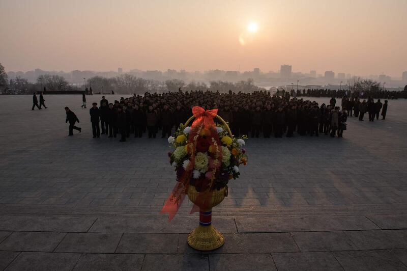 People prepare to pay their respects before the statues of late North Korean leaders Kim Il Sung and Kim Jong Il. AFP