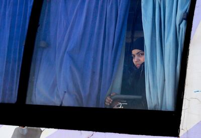 A Syrian woman looks out of the window of a bus as Syrian civilians and rebel fighters evacuated from Eastern Ghouta arrive in a government-held area at the entrance of Harasta on the outskirts of the capital Damascus, on March 26, 2018. 
More than 2,500 Syrian rebels and civilians prepared to leave Eastern Ghouta on March 26 after the largest exodus yet from the opposition enclave, as talks stalled over the final pocket of resistance. / AFP PHOTO / LOUAI BESHARA