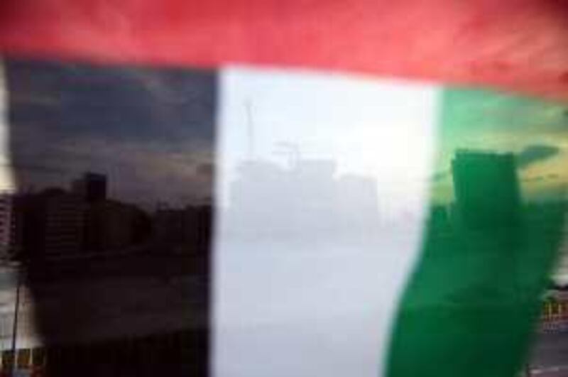 DUBAI, UNITED ARAB EMIRATES - DECEMBER 03:  A construction site is seen behind an UAE flag on December 3, 2009 in Dubai, United Arab Emirates. Stock markets in the Dubai and Abu Dhabi fell sharply this week after state owned company Dubai World asked for more time to pay off depts, amounting to 35Bn GBP. The Dubai economy which has enjoyed years of rapid growth has seen a sharp decline recently as world markets reacted to the global economic crisis.  (Photo by Dan Kitwood/Getty Images) *** Local Caption ***  GYI0059059044.jpg *** Local Caption ***  GYI0059059044.jpg