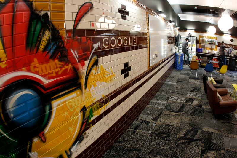 Employees stand in a break room designed as a subway station at the Google building in Zurich. The office boasts a massage room, band rehearsal space, games room, napping areas, a sky lounge, movie room and slides. Photo: Reuters
