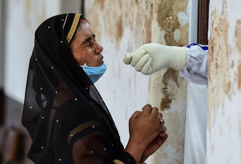 A health official takes a swab sample from a woman to test for the coronavirus at a testing point in Allahabad.  AFP
