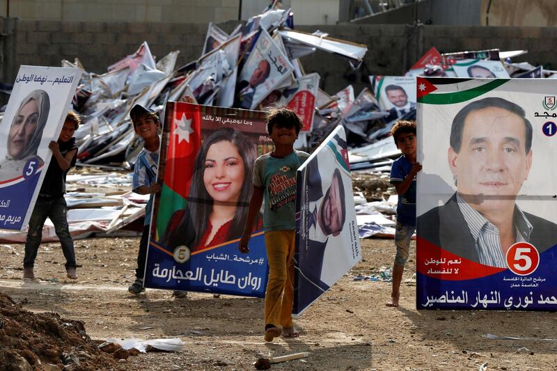 Children pose as they search for wood in parliamentary candidates' posters after parliament elections results were announced in Amman, Jordan November 12, 2020. REUTERS/Muhammad Hamed