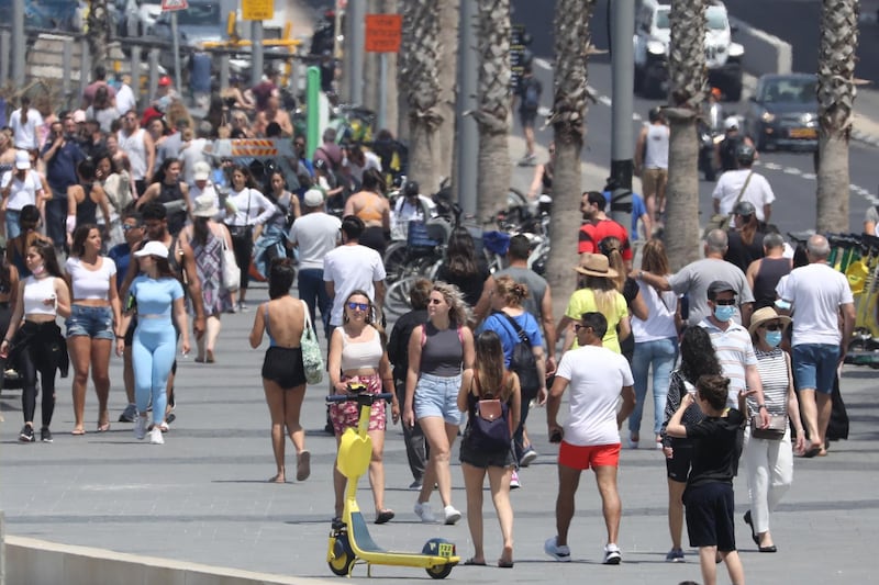 People without face masks enjoy the weather on the beach of Tel Aviv. EPA