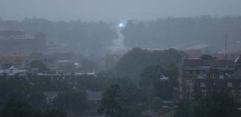 An electric transformer explodes in the distance as heavy rains and wind blanket the Florida State University campus Tallahassee. AP