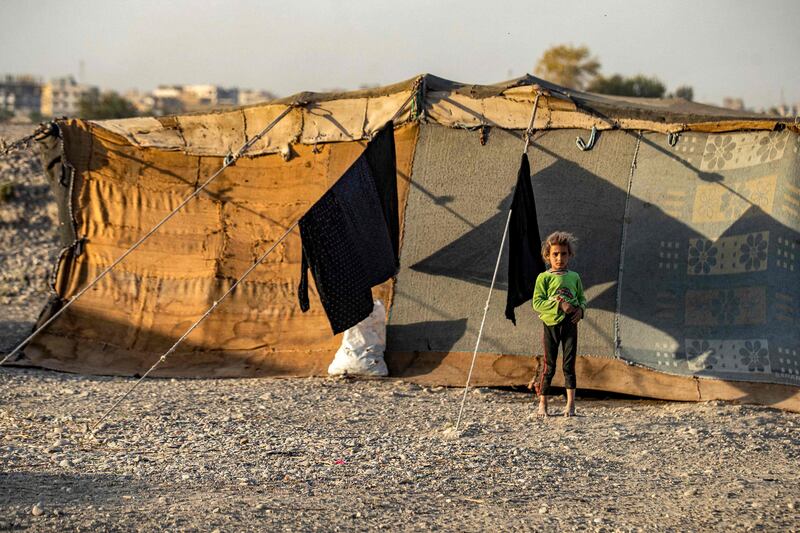 A child stands outside a tent at Yunani camp.