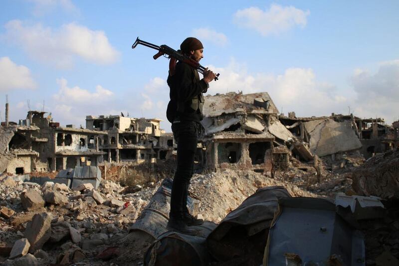 A rebel fighter stands amid the rubble of destroyed buildings in the rebel-held area of Daraa in southern Syria. Mohamad Abazeed / AFP Photo