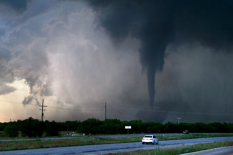 A tornado spins west of Hawley, Texas, US, as cars travel along Route 277. AP