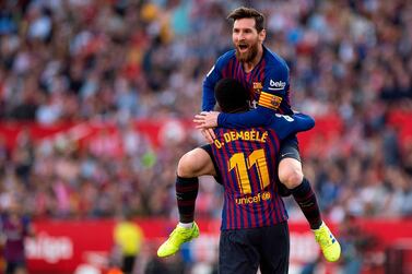 TOPSHOT - Barcelona's Argentinian forward Lionel Messi (back) celebrates with Barcelona's French forward Ousmane Dembele after scoring a goal during the Spanish league football match between Sevilla FC and FC Barcelona at the Ramon Sanchez Pizjuan stadium in Sevilla on February 23, 2019. / AFP / JORGE GUERRERO