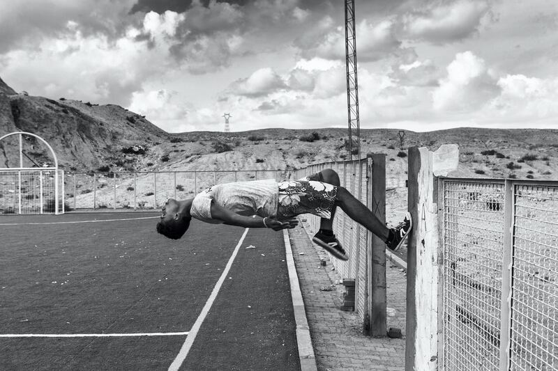 Zied Ben Romdhane, A boy back flips off wall in a soccer field in Umm-Al-Arais, Tunisia. The Arab Street at Gulf Photo Plus, Dubai. Courtesy Zied Ben Romdhane